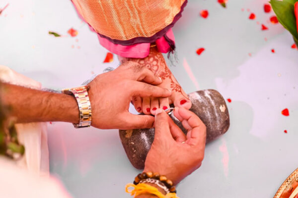 A Tamil wedding Groom wearing Toe ring or metti or minchi to the bride a tamil wedding ritual.
