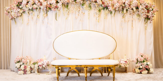 A banquet hall decorated with flowers is set for an engagement party.