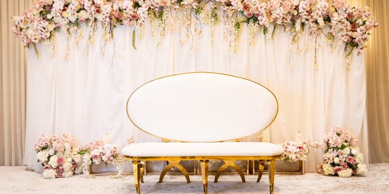 A banquet hall decorated with flowers is set for an engagement party.